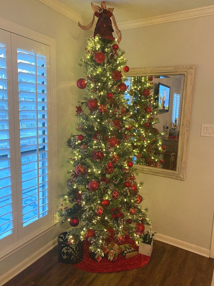 tall and slim Christmas tree with vintage and antique red ornaments and decorations
