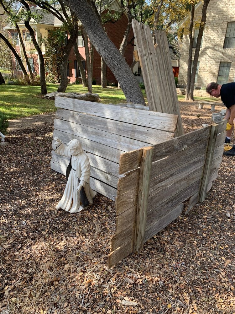 husband building nativity stable from vintage fence pickets outside