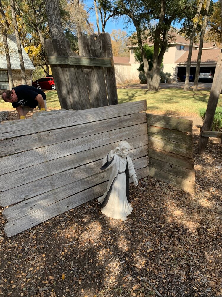 husband building nativity stable from vintage fence pickets outside